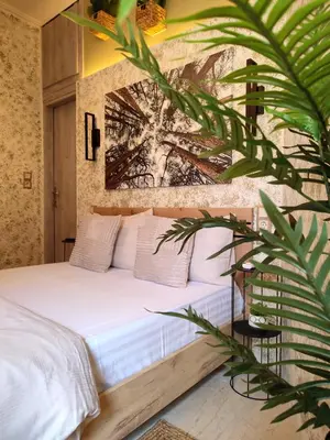 a bedroom with a white bed with a painting on the wall at Elia Studio in Athens