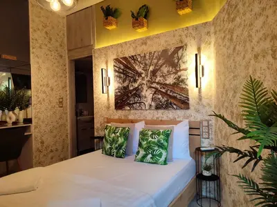 a bedroom with a white bed with a painting on the wall at Elia Studio in Athens