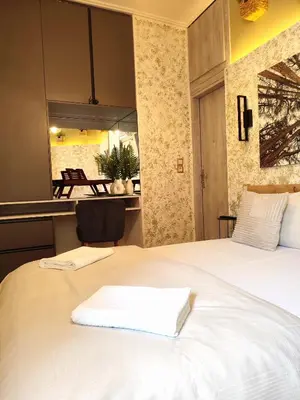 a large white bed with a white towel on it at Elia Studio in Athens