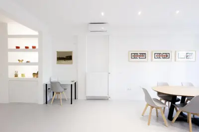 a dining room with white walls and a table and chairs at Comfort Sunny Hub with 2 bdr in Athens