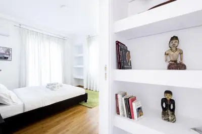 a white bedroom with a bed and a book shelf at Comfort Sunny Hub with 2 bdr in Athens