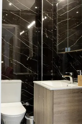 a black tiled bathroom with a toilet and a sink at Comfort Sunny Hub with 2 bdr in Athens
