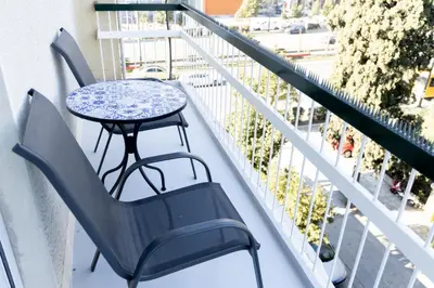 a table and chairs sitting on a balcony at Comfort Sunny Hub with 2 bdr in Athens
