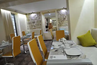 a dining room with tables and yellow chairs at Acropolis Museum Boutique Hotel in Athens
