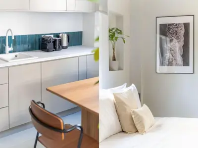 a kitchen with white cabinets and a table with a chair at Premium Apartments in Paleo Faliro by UPSTREET in Athens