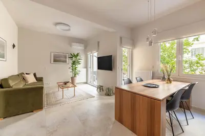 a living room with a couch and a table at Premium Apartments in Paleo Faliro by UPSTREET in Athens