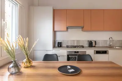 a kitchen with a wooden table with chairs and a dining room at Premium Apartments in Paleo Faliro by UPSTREET in Athens