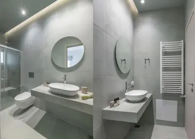 a bathroom with two sinks and a toilet and mirrors at Premium Apartments in Paleo Faliro by UPSTREET in Athens