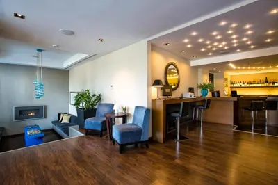 a hotel lobby with a bar and blue chairs at The Athens Gate Hotel in Athens