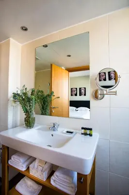 a bathroom with a sink and a mirror at The Athens Gate Hotel in Athens