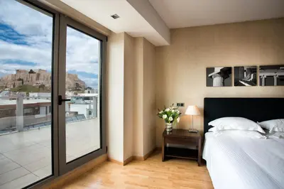 a bedroom with a bed and a large window at The Athens Gate Hotel in Athens