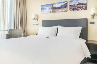 a hotel room with two beds and a chair at The Athens Gate Hotel in Athens