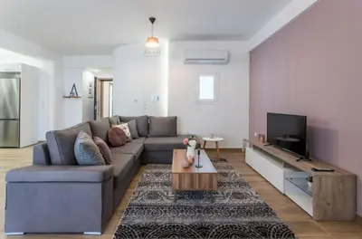 a living room with a couch and a tv at Athens Hill Suite in Athens