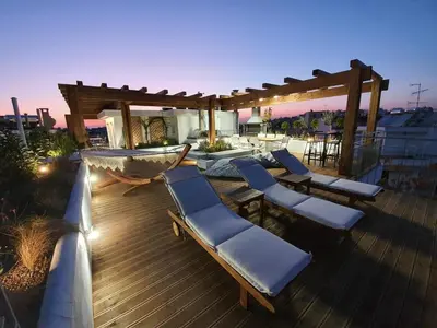 a deck with lounge chairs and a hammock on it at Athens Hill Suite in Athens