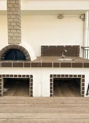 an outdoor kitchen with a sink and a brick oven at Athens Hill Suite in Athens