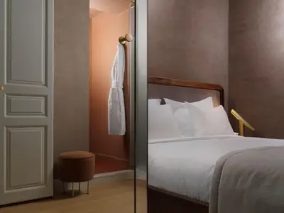 a bedroom with a bed and a door with a robe at Monument Hotel in Athens