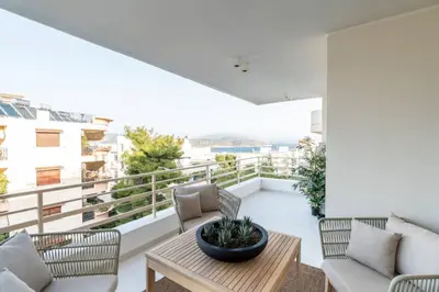 a room with a balcony with chairs and a table at 2BD Boho Sea View Apartment by The Olon in Vari