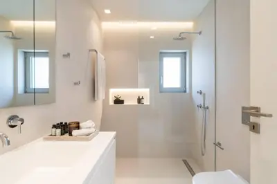 a white bathroom with a shower and a sink at 2BD Boho Sea View Apartment by The Olon in Vari