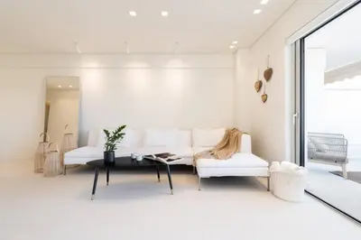 a living room with a white couch and a table at 2BD Boho Sea View Apartment by The Olon in Vari
