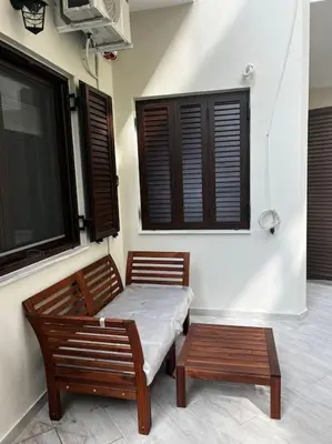 a table and two chairs in a room with windows at Olivia Luxury Apartment Palio Faliro in Athens