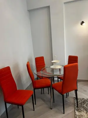 a dining room with a glass table and red chairs at Olivia Luxury Apartment Palio Faliro in Athens