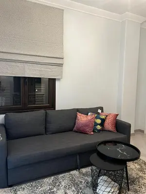 a living room with a blue couch and a table at Olivia Luxury Apartment Palio Faliro in Athens