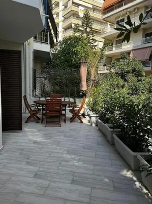 a patio with a table and chairs in a building at Olivia Luxury Apartment Palio Faliro in Athens
