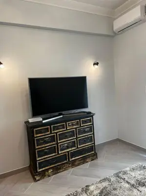 a flat screen tv sitting on top of a dresser at Olivia Luxury Apartment Palio Faliro in Athens
