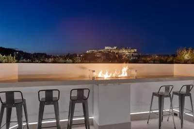 a bar with chairs and a fire place on a balcony at Koniama Acropolis in Athens