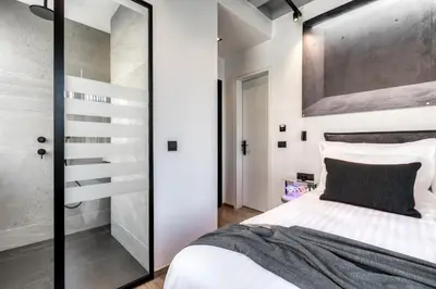 a bedroom with a white bed and a glass staircase at Koniama Acropolis in Athens