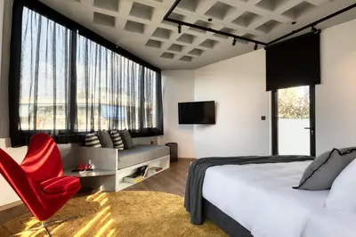 a bedroom with a bed and a red chair at Koniama Acropolis in Athens