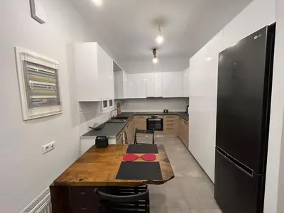 a kitchen with a wooden table and a black refrigerator at ATHENS SEA VIEW GUEST HOUSE in Athens