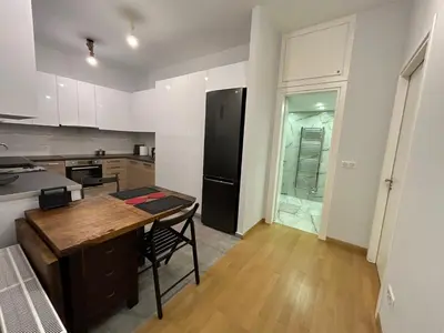 a kitchen with a wooden table and a black refrigerator at ATHENS SEA VIEW GUEST HOUSE in Athens