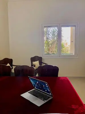 a laptop computer sitting on a red table with chairs at Feels like home (Vari) in Vari