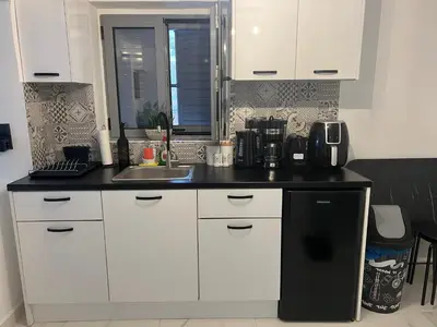 a kitchen with white cabinets and a sink at Riviera-MelRod-Athens in Athens