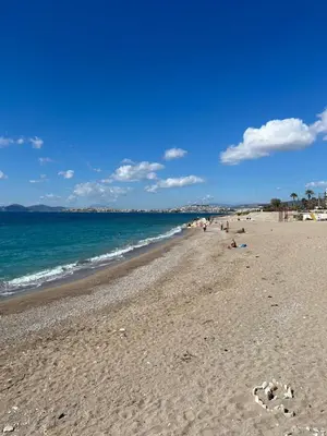 a beach with people on the sand and the ocean at Riviera-MelRod-Athens in Athens
