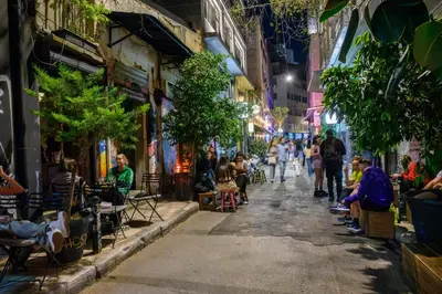 people walking down a street at night at Psiri Vibes in Athens