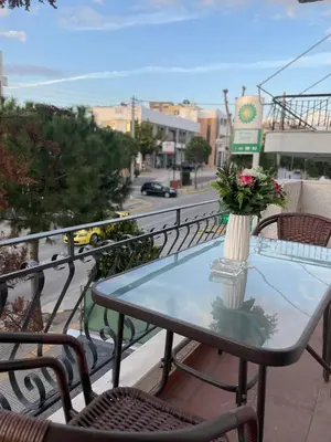 a table with a vase of flowers on a balcony at AIOLOS LUXURY alimos center Suite II near the sea in Athens