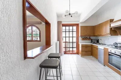 a kitchen with two stools and a mirror on the wall at AIOLOS LUXURY alimos center Suite II near the sea in Athens
