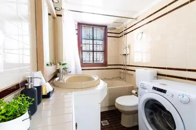 a bathroom with a toilet and a washing machine at AIOLOS LUXURY alimos center Suite II near the sea in Athens