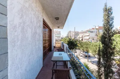 a table on the balcony of a building at AIOLOS LUXURY alimos center Suite II near the sea in Athens