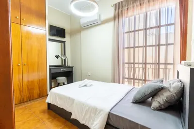 a bedroom with a bed and a large window at AIOLOS LUXURY alimos center Suite II near the sea in Athens