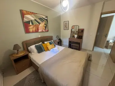 a bedroom with a large bed and a mirror at AIOLOS COZY alimos center APARTMENT near the sea in Athens