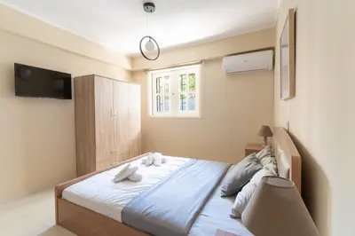 a bedroom with a large bed with a window at AIOLOS COZY alimos center APARTMENT near the sea in Athens