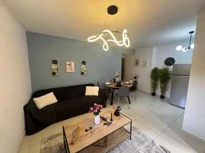 a living room with a couch and a table at AIOLOS COZY alimos center APARTMENT near the sea in Athens