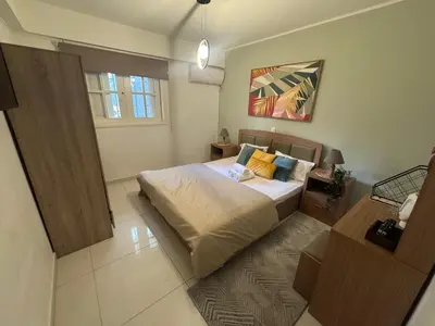 a bedroom with a large bed in a room at AIOLOS COZY alimos center APARTMENT near the sea in Athens