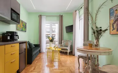 a kitchen with a table and a living room at Olympian Zeus Residences in Athens