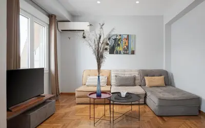 a living room with a couch and a tv at Olympian Zeus Residences in Athens