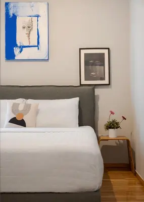 a bedroom with a large white bed and a table at Olympian Zeus Residences in Athens