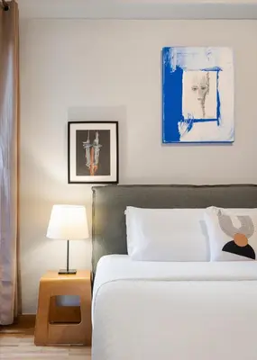 a bedroom with a white bed and a table with a lamp at Olympian Zeus Residences in Athens